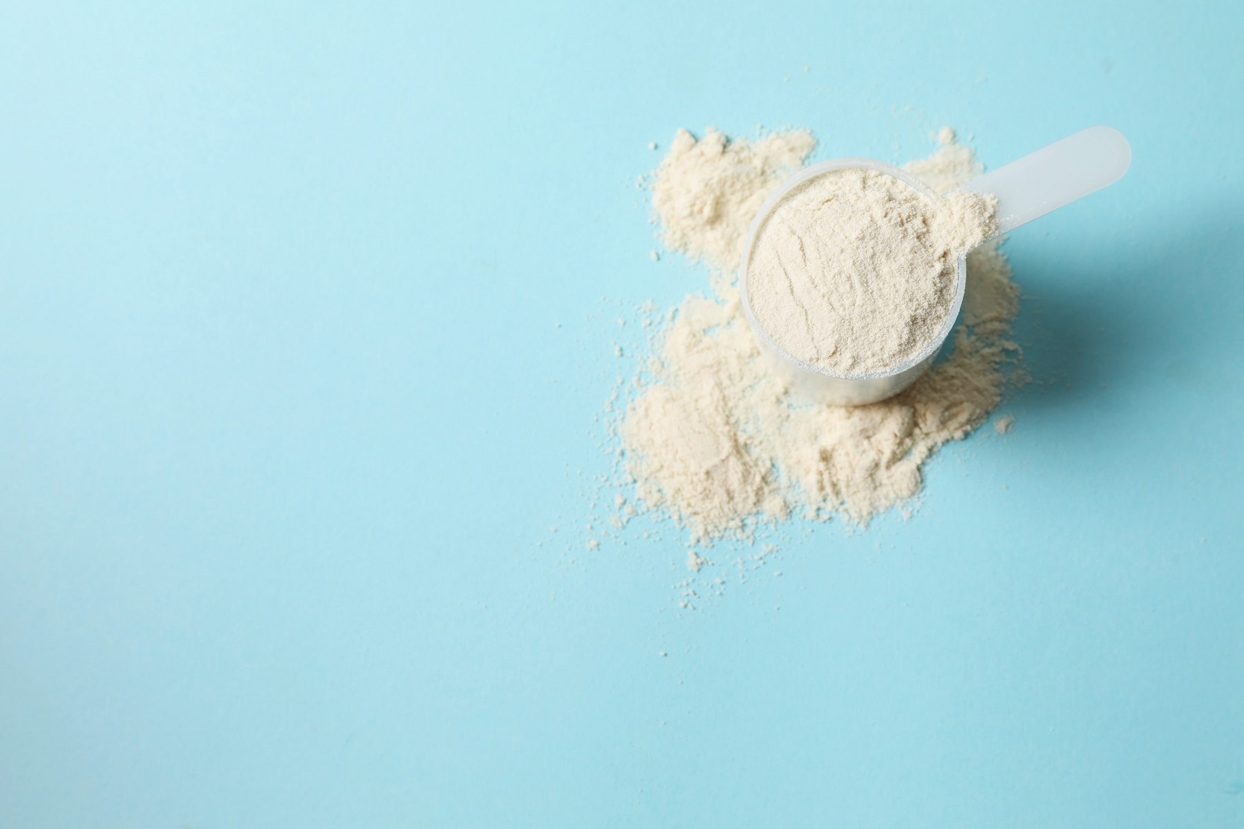 Best quality protein powder vanilla scoop blue backdrop