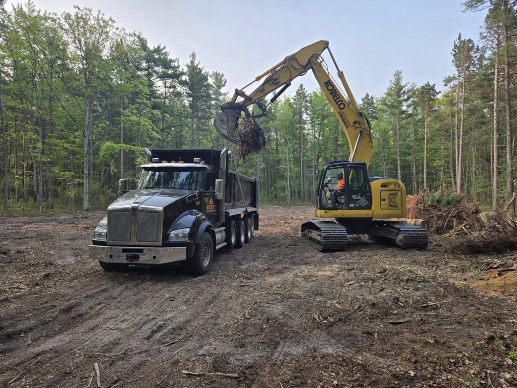 Avery Excavating Backhoe clearing land for build site